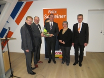 Felix Schreiner übergibt Dr. Meister einen Presentkorb mit Produkten der Region